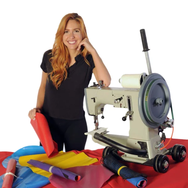 Woman standing with a FixMyInflatable Portable Sewing Machine and colorful inflatable repair vinyl materials